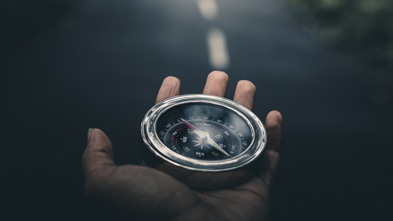 Compass in hand with road in background